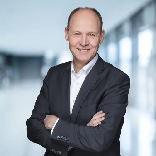Ein Mann im Anzug mit verschränkten Armen